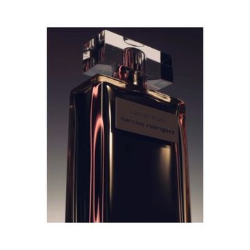 Close-up studio shot of a rectangular black perfume bottle with a reflective silver cap and label with the name 'Narciso Rodriguez'.