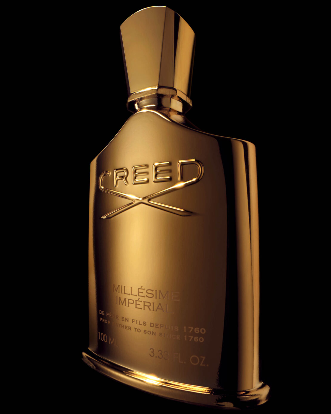 A gold Creed Millesime Imperial perfume bottle is prominently displayed against a dark background, emphasizing its sleek design.