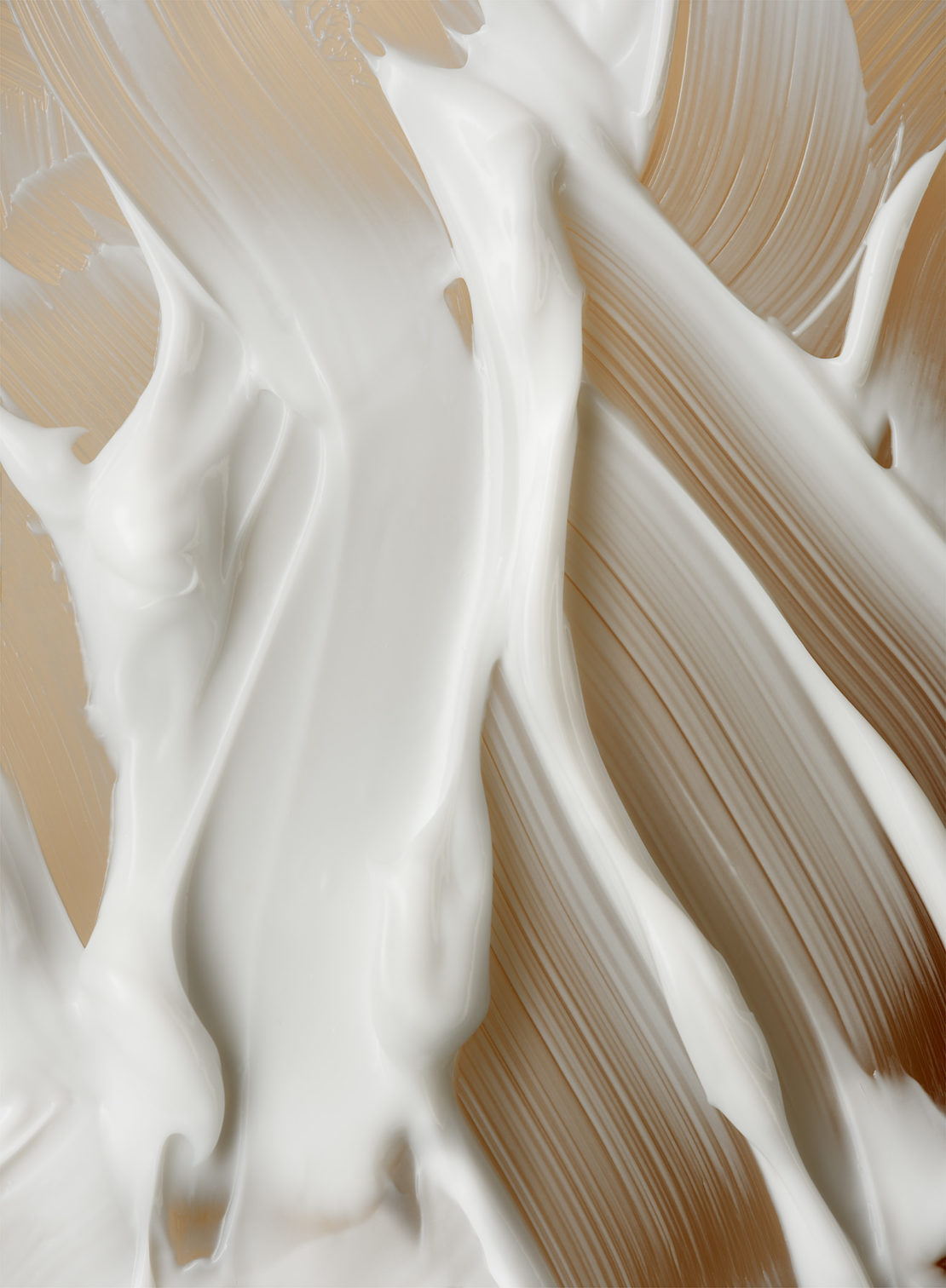 Abstract image of thick white cream or lotion swirled against a soft beige background, creating a textured and smooth appearance.