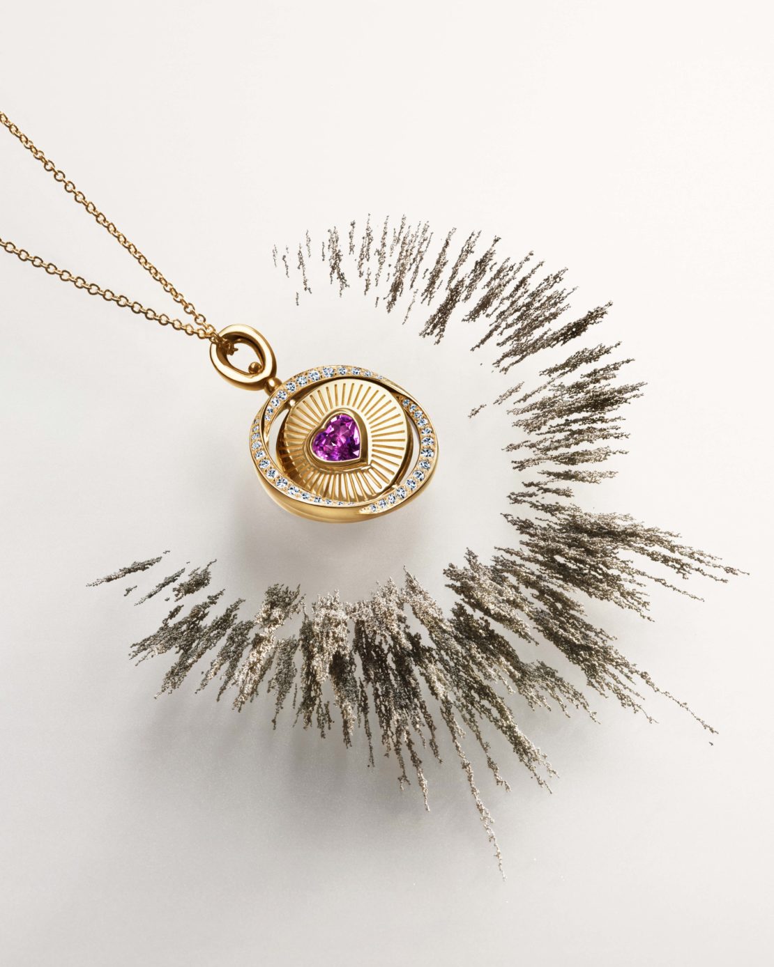Elegant gold necklace pendant with purple heart-shaped gemstone surrounded by diamonds displayed with a ring of dark powder.