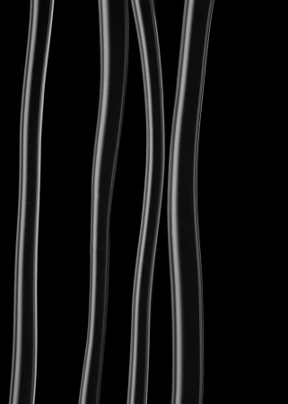 Close-up abstract photograph of four vertical translucent white glass tubes against a solid black background.