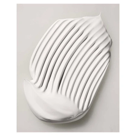 Close-up shot of a swirl of white cream product with distinct ridges, set against a light grey backdrop, highlighting the texture.