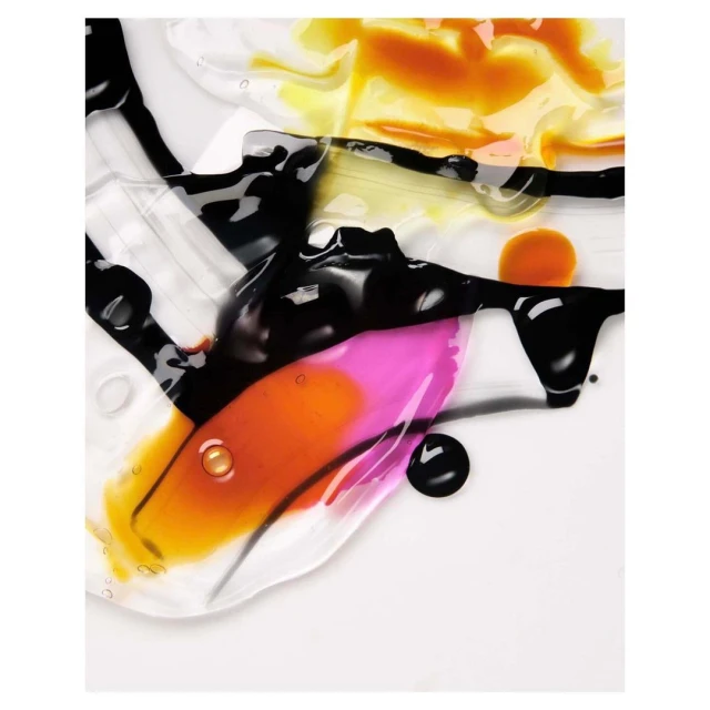 Abstract close-up of beauty product smears in pink, yellow, and black on a white background, showing texture and color variations.