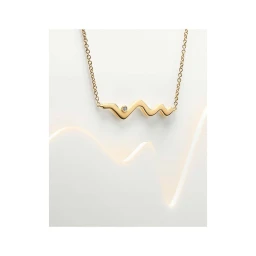 A delicate gold necklace with a zigzag pendant and embedded diamond set against a clean white seamless backdrop.
