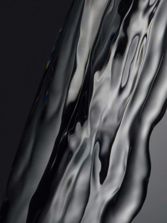Close-up abstract photograph of cascading liquid metal with reflective ripples and fluid waves against a dark grey gradient background.
