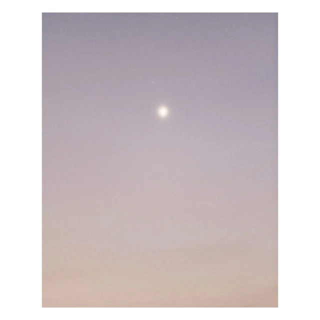 Sky at dusk with soft gradient of colors. Gradient from pale orange at the bottom to soft violet at the top with a bright celestial orb.