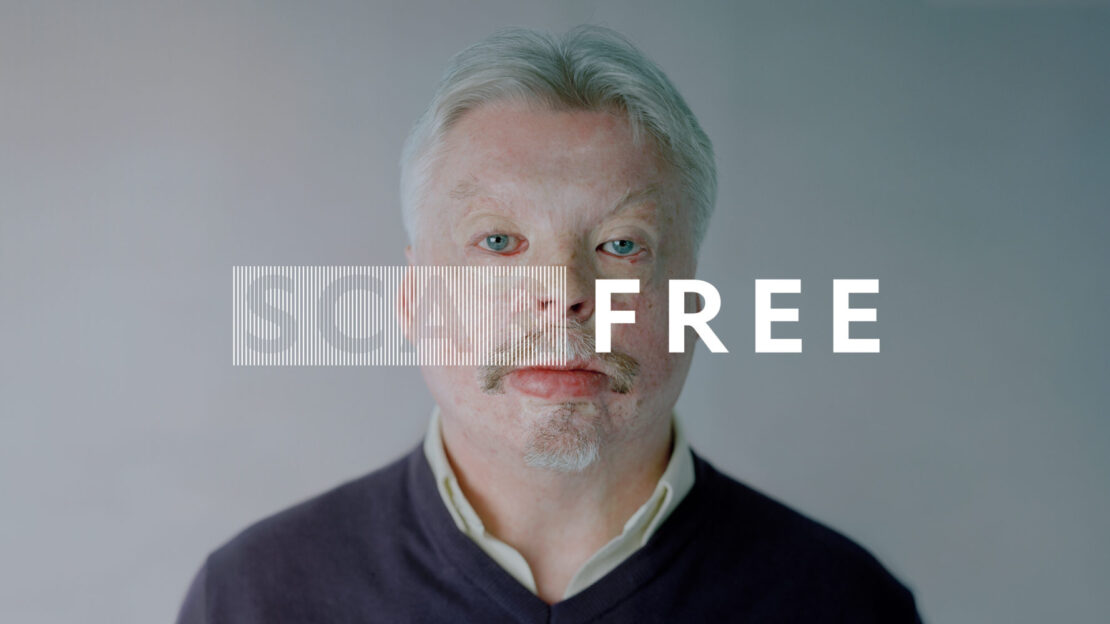 Portrait of a light-skinned older adult male with a mustache, in a navy v-neck sweater, against a grey background with text overlay.