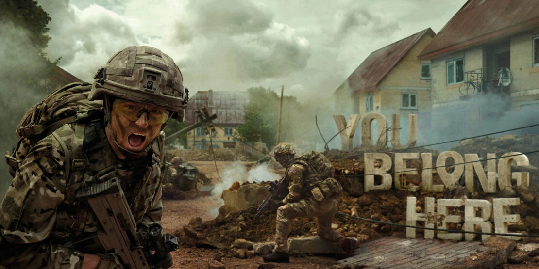 Soldier in camouflage yells while holding a rifle in a war-torn environment with damaged buildings, smoke, and debris in an outdoor setting.