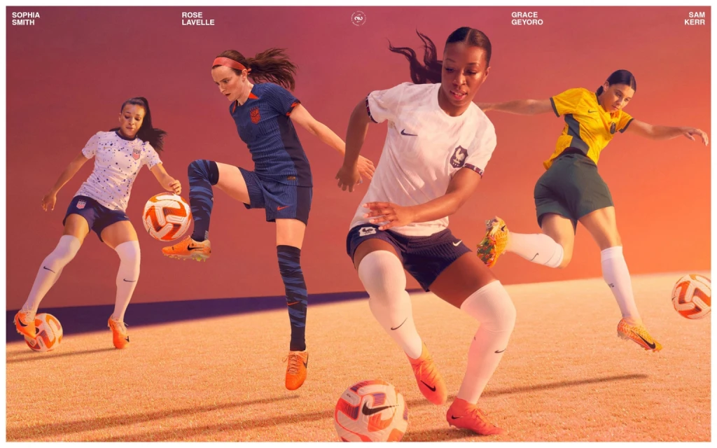 Four female soccer players in sports attire each kicking a soccer ball. The scene is set against a gradient background of orange and purple hues.
