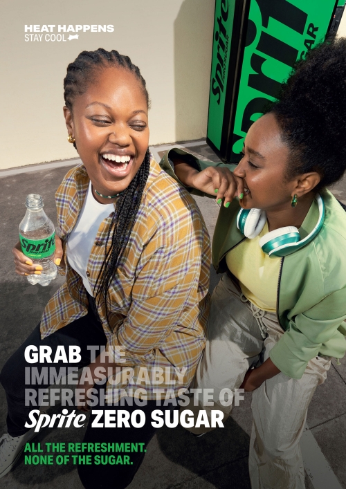 Two young women laughing together while sitting outside with a bottle of Sprite Zero Sugar drink and headphones. Heat Happens Stay Cool.