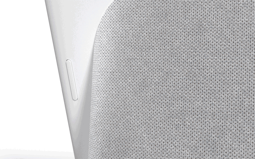 Close-up of a gray smart speaker with a fabric texture and white trim, showcasing modern tech design against a plain backdrop.