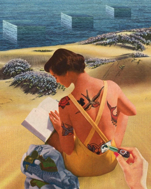 Woman with tattoos reads on a sandy beach near ocean with surreal geometrical shapes. Hand holding daisy pushes into her back.