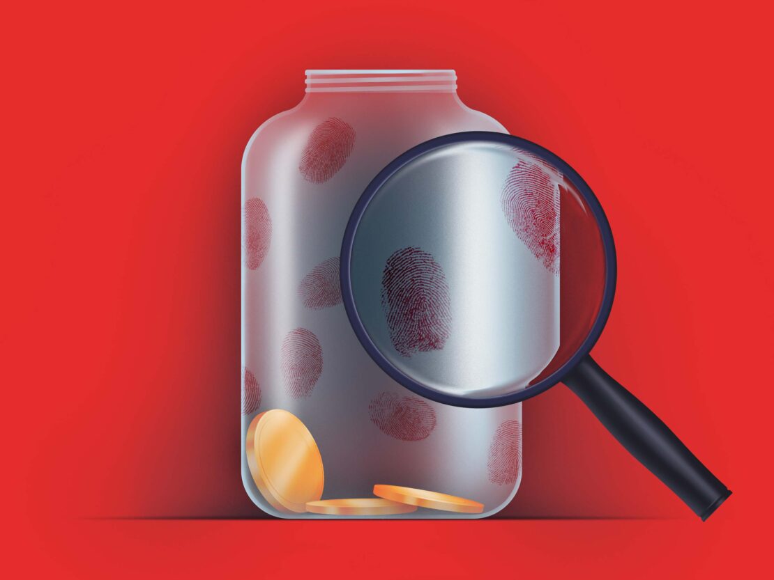 Conceptual image of a clear jar containing gold coins and red fingerprints, with a magnifying glass, set against a red backdrop.