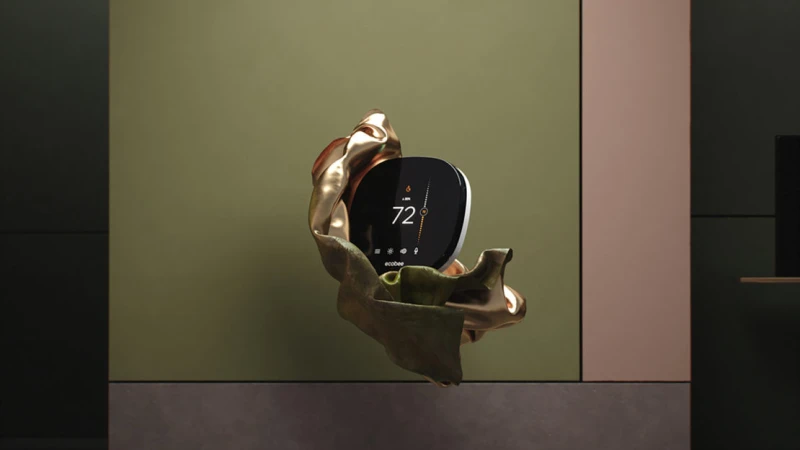 Smart thermostat displayed on a golden cloth, in front of a wall with pastel green and pink, promoting home climate control.