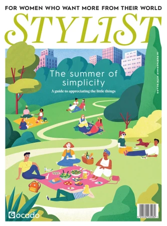 Stylist magazine cover illustration: people picnicking in a city park with green trees and modern buildings. Cover text reads: The summer of simplicity.