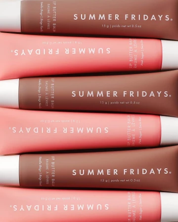 Cosmetic product still life: Close-up of Summer Fridays Lip Butter Balm tubes in pink and brown, stacked in a studio product shot.