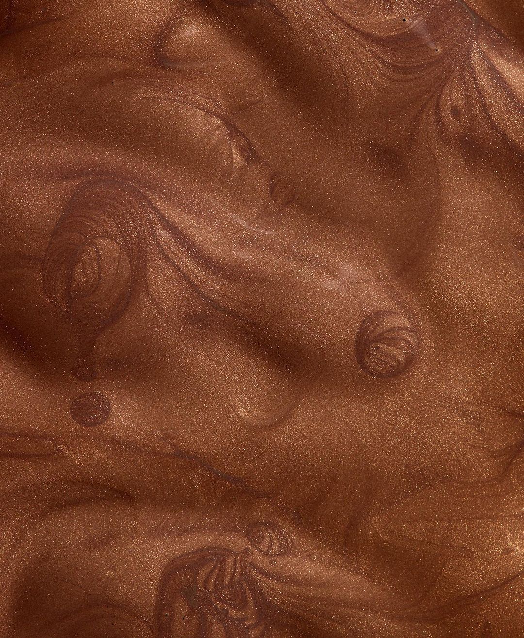 Abstract copper-toned liquid forms swirls and eddies of shimmery, metallic texture; a rich, molten bronze color fills the frame.