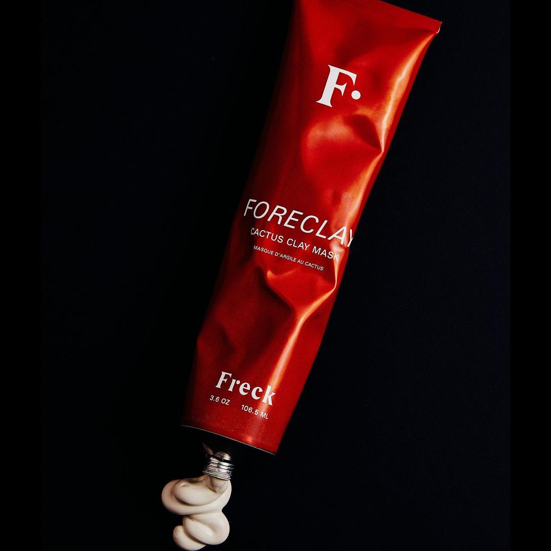 Studio shot of 'Foreclay' cactus clay mask tube from Freck Beauty, with its pale contents spilling out against a black background.