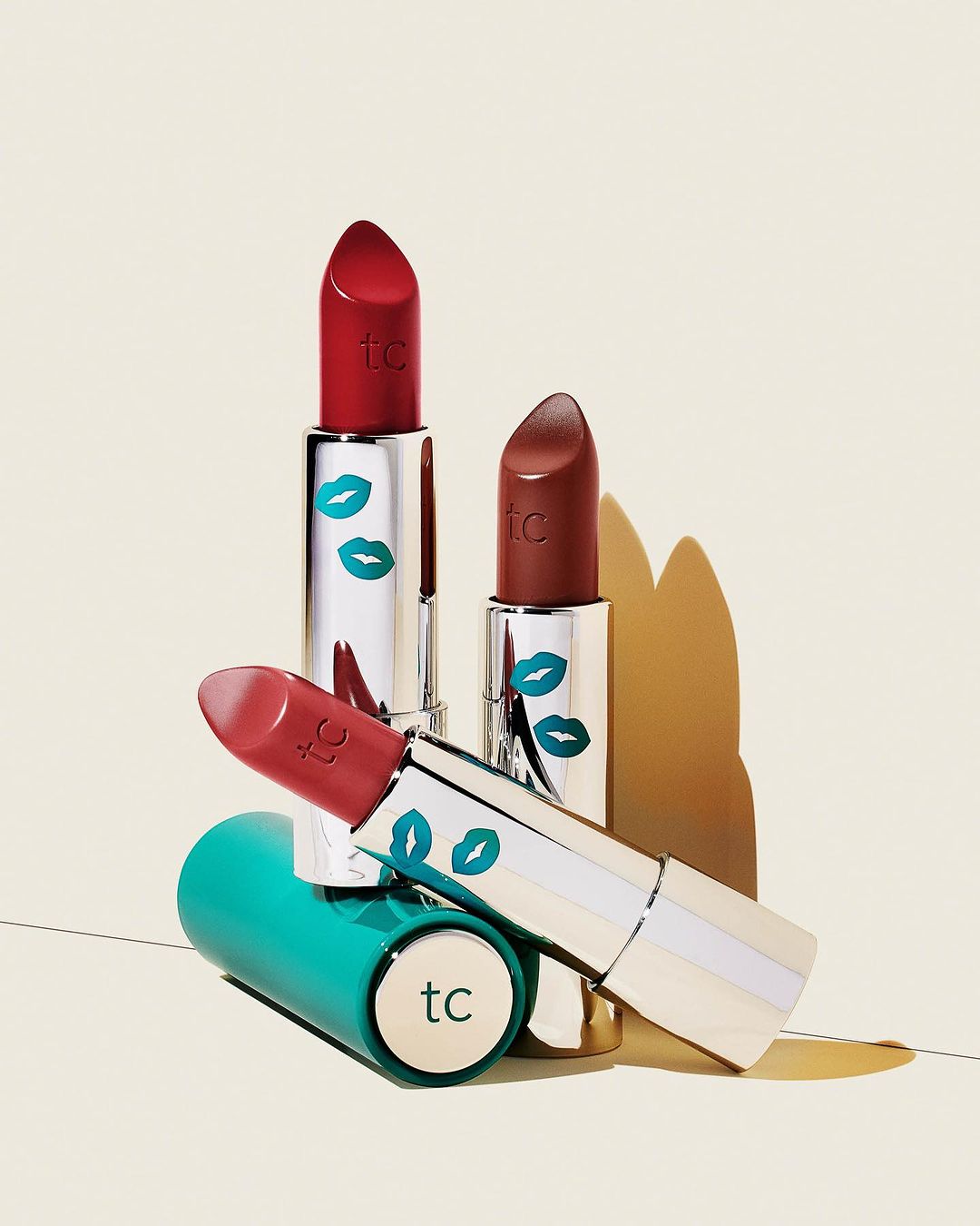 Close-up of assorted lipsticks with colorful packaging, illuminated by soft, diffused light against a neutral background.