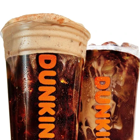 Two Dunkin' beverages are displayed side by side, featuring iced coffee and a cold brew with a thick layer of foam and the Dunkin' logo.