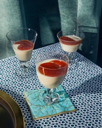 Three stem glasses filled with layered dessert and caramel sauce on a lace tablecloth by Jenny Huang