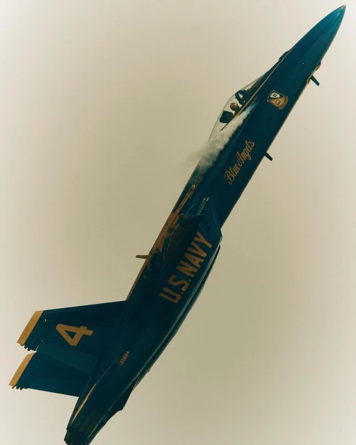Blue Angels jet soars in the sky, showcasing a dynamic display of aviation skill and precision in a striking blue and yellow color scheme.