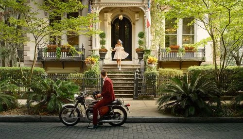 Retro-style scene with a woman in a polka dot dress descending steps of a classic building toward a man on a vintage motorcycle.