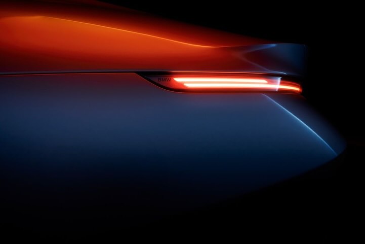 Sleek automotive design showcasing the rear of a modern car in dark with illuminated orange and red taillight. Car tail light detail.