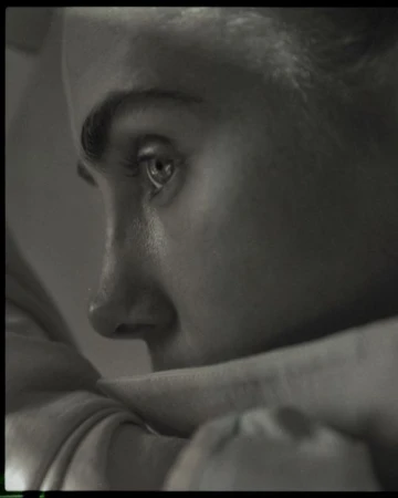 Close-up monochrome portrait profile of a person resting chin on crossed arms, shot by David Daub.