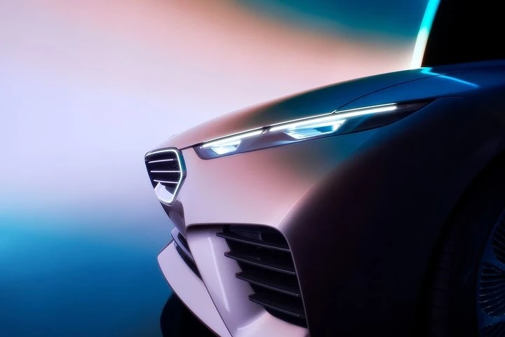 Close-up of a modern concept car featuring sleek headlights and a distinctive grill design, set against a gradient background.