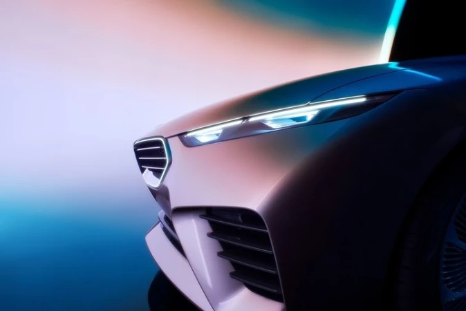 Close-up of a modern concept car featuring sleek headlights and a distinctive grill design, set against a gradient background.