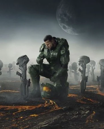 Man in futuristic armor kneels among fallen helmets and rifles in a solemn, desaturated outdoor scene with a large moon in the sky.