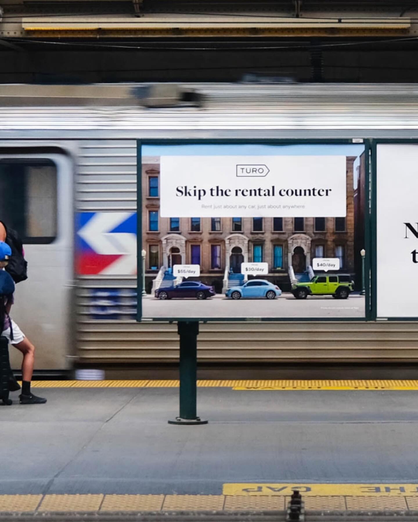 Billboard ad for Turo car rentals on a subway platform. The ad features images of various cars with rental costs.