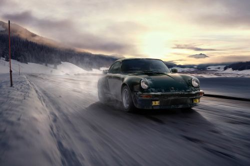 Dark green vintage Porsche car driving on a snowy road with mountains and a sunset sky in the background, motion blur.