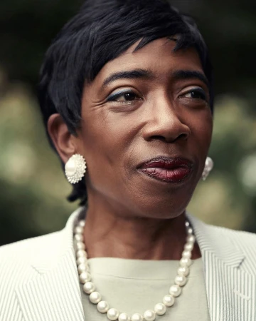 Portrait of a mature Black woman wearing a pearl necklace and white striped blazer by Victoria Will