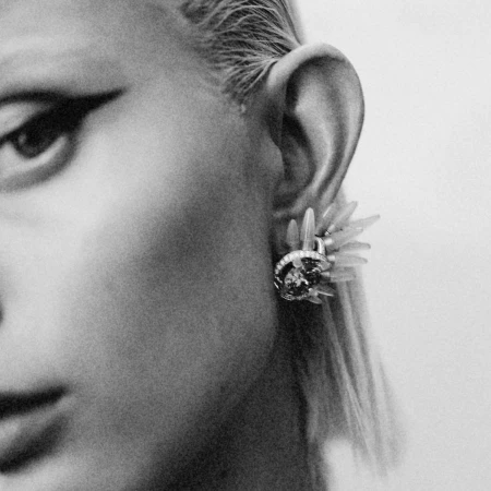 Extreme close-up monochrome portrait of a person wearing a sculptural jewelled ear cuff by photographer Victoria Will