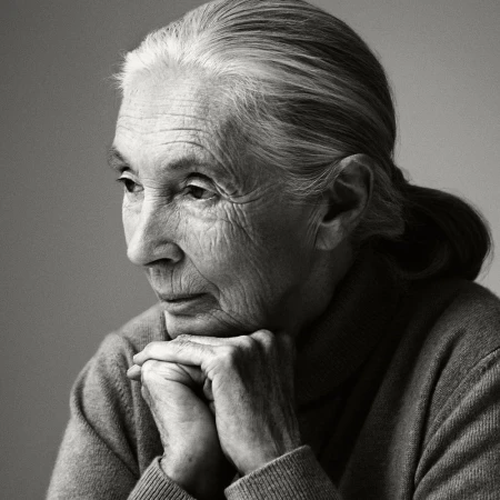 Black and white portrait of an elderly woman with her hands clasped together looking off to the side with a thoughtful expression.
