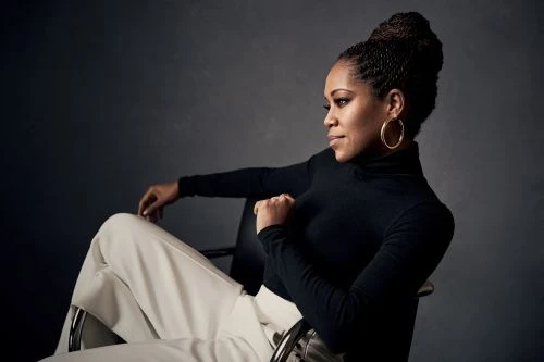 Regina King portrait by Victoria Will wearing a black turtleneck and light trousers