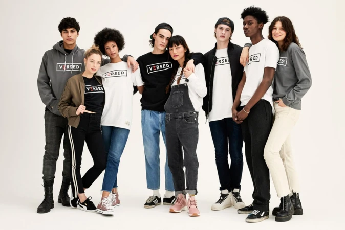 Group of eight multi-ethnic young adult models wearing branded streetwear clothing in a studio shot against a white backdrop.