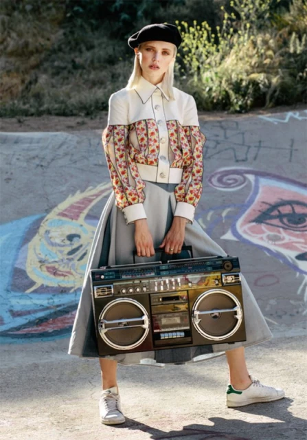 Woman in beret, posing with vintage boombox in skatepark, showcasing fashion, style and urban lifestyle in outdoor setting.
