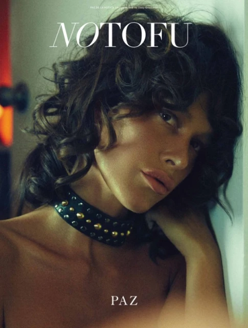 Portrait of a woman with shoulder-length curly dark hair, a studded choker necklace, soft lighting, and fashion magazine text overlays.