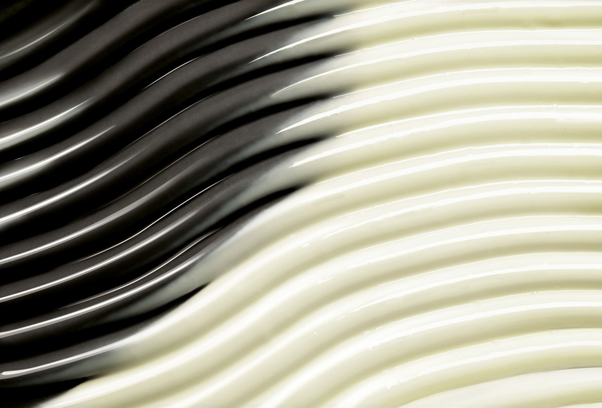 Abstract wavy texture in dark gray and light beige, creating a smooth and fluid pattern suitable for backgrounds.