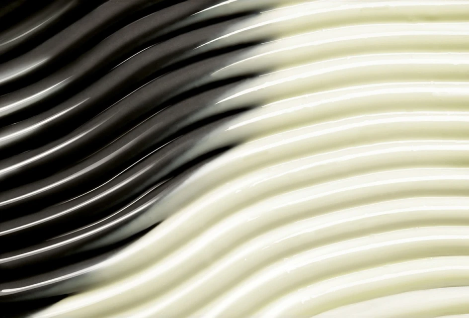 Abstract wavy texture in dark gray and light beige, creating a smooth and fluid pattern suitable for backgrounds.