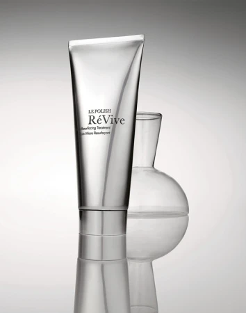 Silver tube of Le Polish ReVive skin resurfacing treatment alongside a transparent glass lab flask against a gradient background.