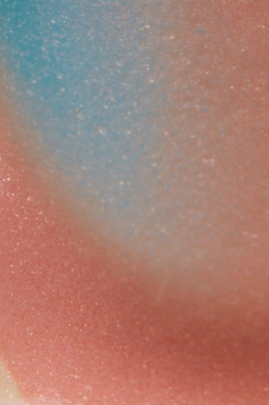 Abstract background featuring a gradient of pink, peach, and light blue with subtle sparkling effect. Smooth texture and diffused lighting.