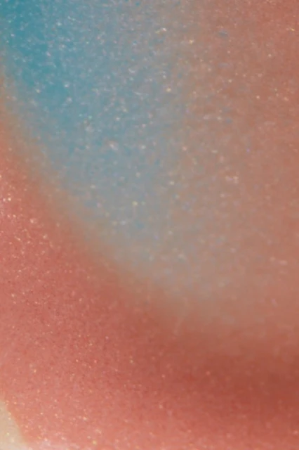 Abstract background featuring a gradient of pink, peach, and light blue with subtle sparkling effect. Smooth texture and diffused lighting.