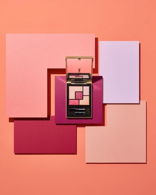 YSL eyeshadow palette kit on layered pink and peach square boards, showcasing makeup and geometric shapes for beauty advertising.