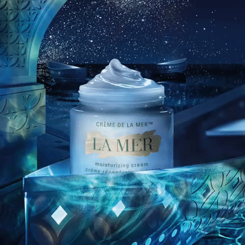 Close-up of a jar of La Mer moisturizing cream against a backdrop of ice-like structures and a star-filled sky, skincare product shot.