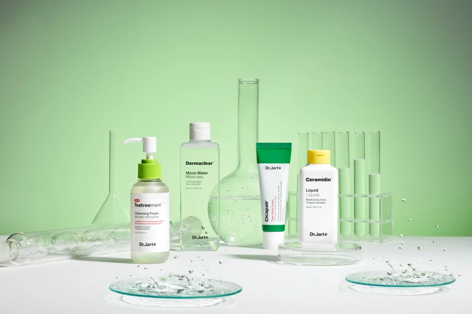 Still life of Dr.Jart+ skincare products including cleansers, toners, and moisturizers, arranged with laboratory glassware on a white surface.