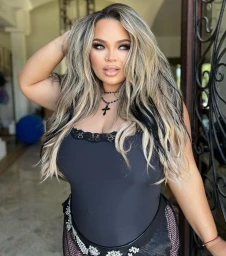 Portrait of a blonde woman wearing a black top and crucifix necklace with make-up by Alex T. in Los Angeles